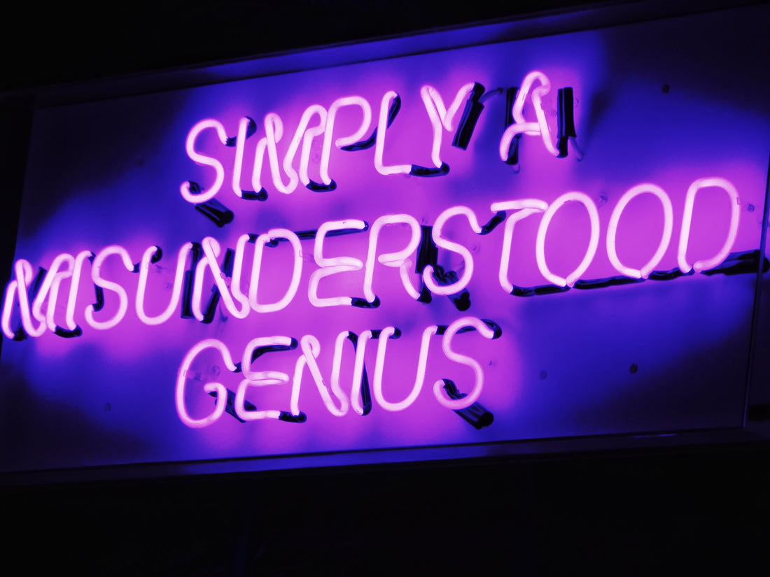 Neon sign that says "simply a misunderstood genius"
